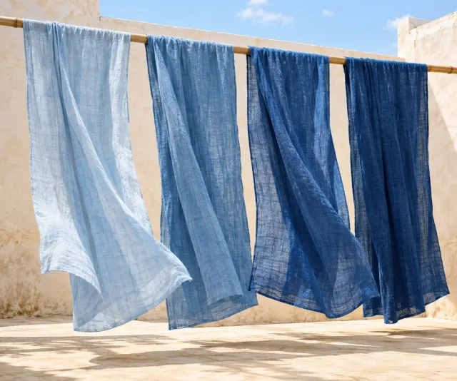 Sunlit indigo cloths drying in a bright courtyard