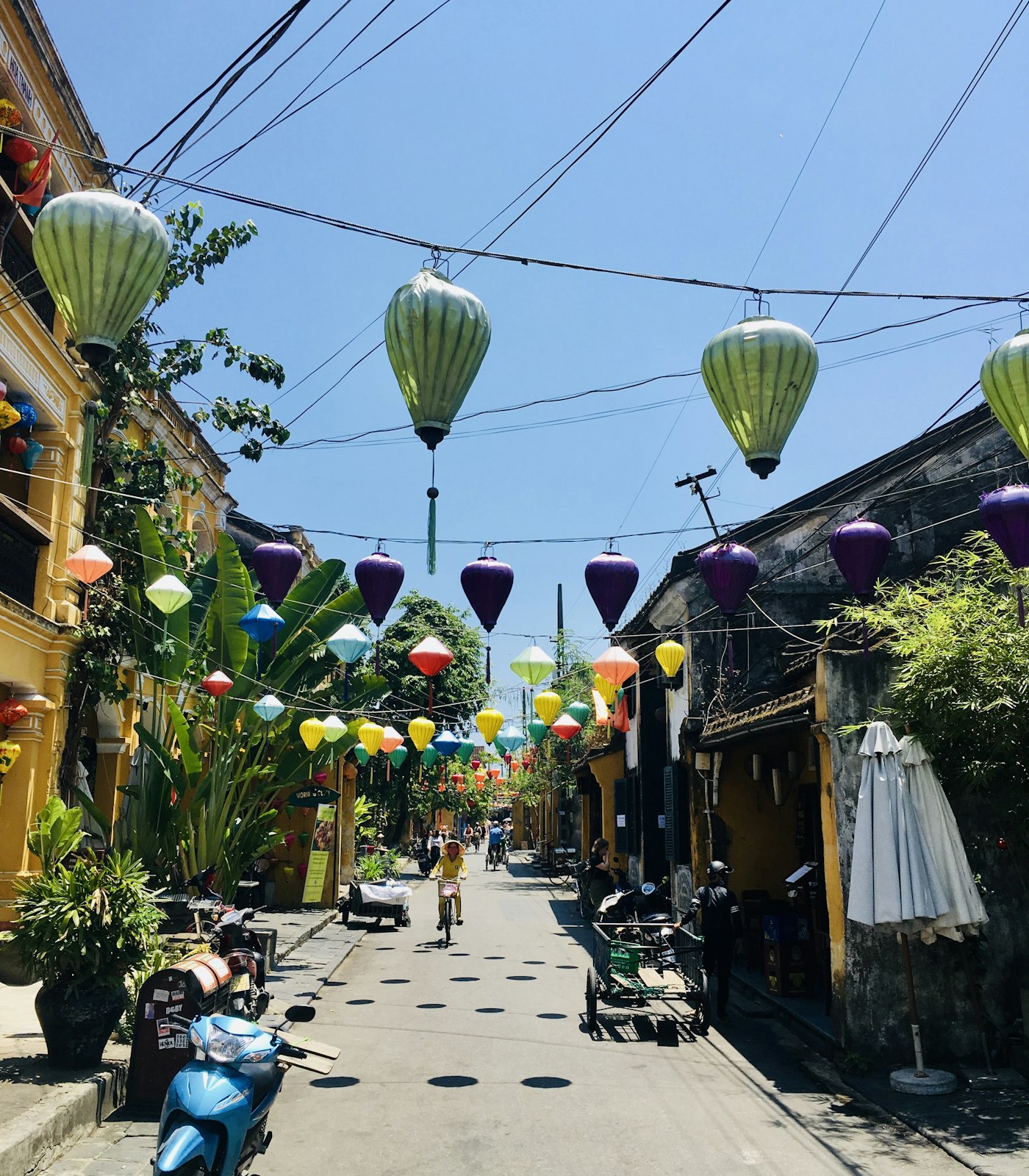 Lanterns strung above a yellow-walled street in Hội An